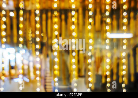 Abstract christmas lights shop windows. Bright circles bokeh from the lights of night windows. Illumination on shop, defocus and blur. Bokeh from the  Stock Photo
