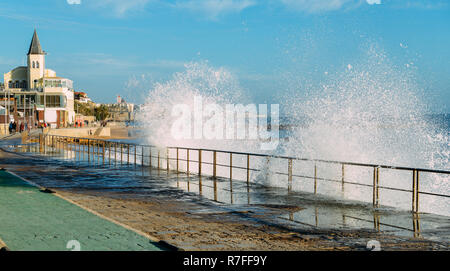 Spray from waves splashing on boardwalk leading to Tamariz beach in the Atlantic resort town of Estoril near Lisbon, Portugal. Stock Photo