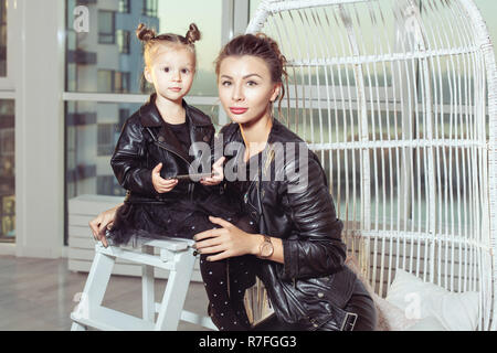 Portrait of a young mother and her daughter in black clothes. Stock Photo