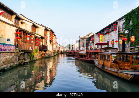 Suzhou, China - August 12, 2011: A canal in the middle of typical houses with paper lantern and wooden boats Stock Photo