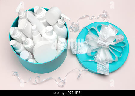 Cosmetics as a present. Open large round gift box filled with cosmetic products. Close-up, top view Stock Photo