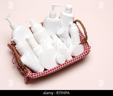 Wicker basket filled with cosmetics. Variety of different cosmetic products. Close-up, top view Stock Photo