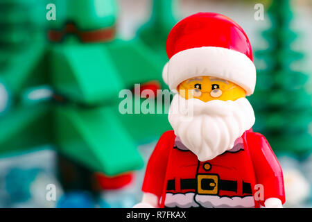 Tambov, Russian Federation - September 02, 2018 Portrait of Lego Santa Claus minifigure against Christmas trees. Close-up. Stock Photo