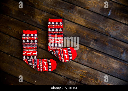 warm wool red Christmas socks with deer on wooden floor top view. new year 2019 Stock Photo