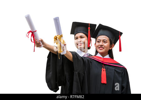 Two female Asian students in graduation gown holding the diplomas with hands stretching forward Stock Photo