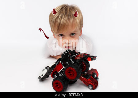 Naughty or good child for Christmas? PF or letter to Santa-Claus for Christmas. Little child boy appearing as an adorable angelic devil Stock Photo