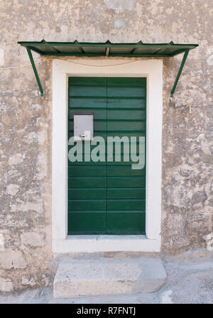 Green wooden doors with silver mailbox on a stone house. Exterior architectural details Stock Photo