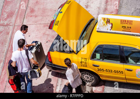 Miami Beach Florida,Ocean Drive,taxi,taxis,cab,cabs,yellow color,adult adults man men male,woman women female lady,couple,driver,trunk,luggage,suitcas Stock Photo