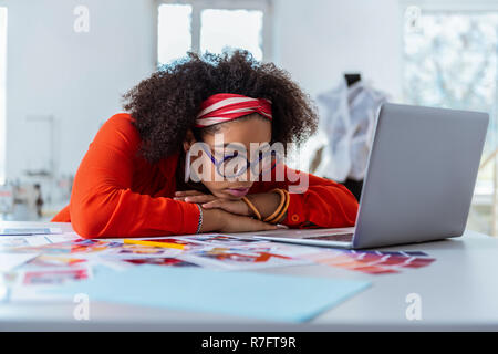 Tired good-looking African American woman leaning on her crossed hands Stock Photo