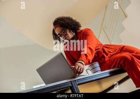 Serious short-haired African American woman touching her laptop Stock Photo