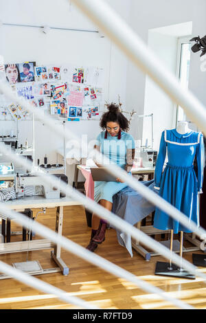 Smiling curvy African American in blue dress browsing the net Stock Photo