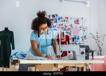 Professional female designer with one hand covered in tattoo Stock Photo