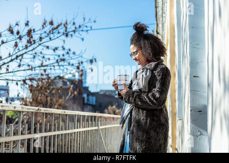 Smiling short-haired African American covered in grey coat and scarf Stock Photo