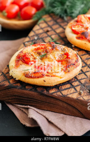 Mini pizzas margheritas on served on a wooden board. Wooden back Stock Photo