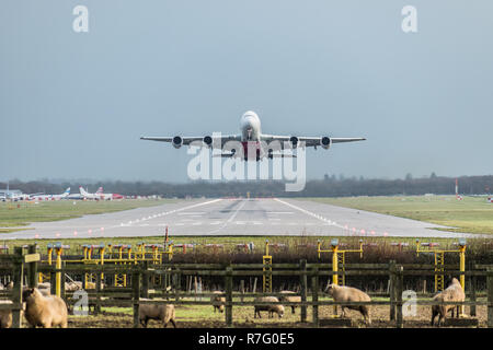 GATWICK AIRPORT, ENGLAND, UK – DECEMBER 09 2018: View directly down the runway as an Emirates Airline plane takes off from London Gatwick Airport Stock Photo