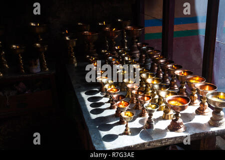 Traditional Buddhist butter lamps in Lamayuru Monastery, Ladakh, Jammu and Kashmir, India Stock Photo