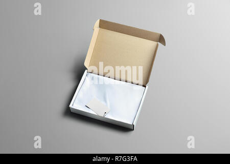 Studio mockup of carton box for clothes . An open cardboard box  with  blank t-shirt of the gray background. Template can use for you showcase. Stock Photo