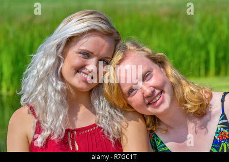 Portrait of two close young dutch sisters  in green nature Stock Photo