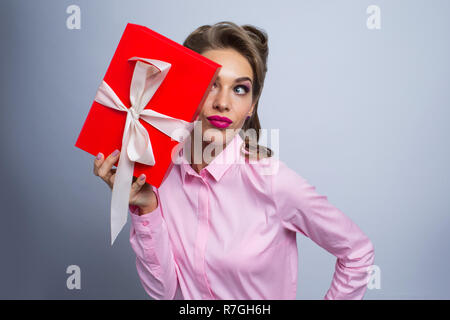 Happy beautiful funny woman holding gift box, listening Stock Photo