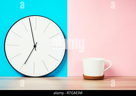 vintage wall clock and cup of coffee on pink and blue pastel background Stock Photo