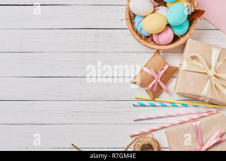 Background with easter eggs, gift boxes and decorations on white, top view with copy space Stock Photo
