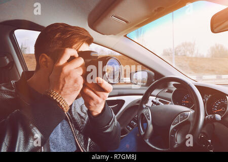 A man is taking pictures from a car window. Photographer traveler. The work of a private detective. Stock Photo