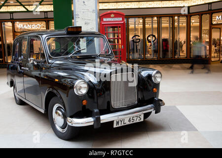 Luxurious old retro automobile and vintage red call box exhibited in a large hall of big moll Stock Photo