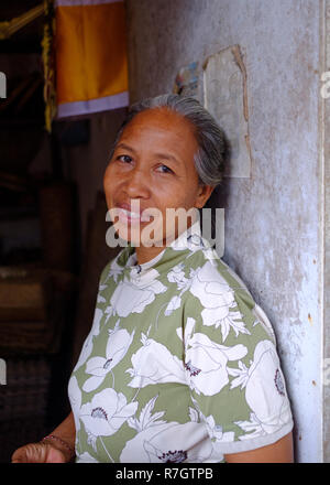 An elderly lady manning a market stall in Bali, Indonesia Stock Photo