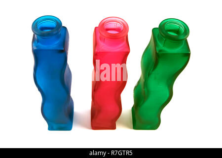 Three wavy glass flower vases of different colors isolated on white background, top perspective view Stock Photo