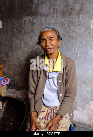 An elderly lady manning a market stall in Bali, Indonesia Stock Photo