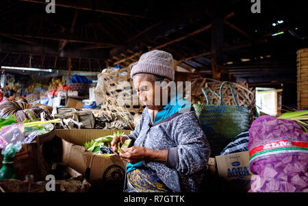 An elderly lady manning a market stall in Bali, Indonesia Stock Photo