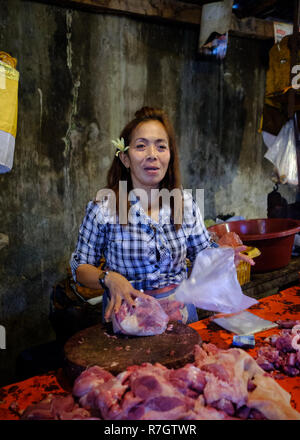 An elderly lady manning a market stall in Bali, Indonesia Stock Photo