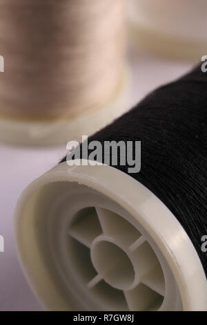 Bobbins with threads on the background of an old wooden table, sewing background Stock Photo