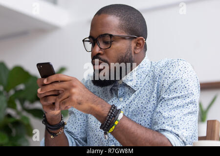 Portrait black man chatting browsing internet using mobile phone Stock Photo