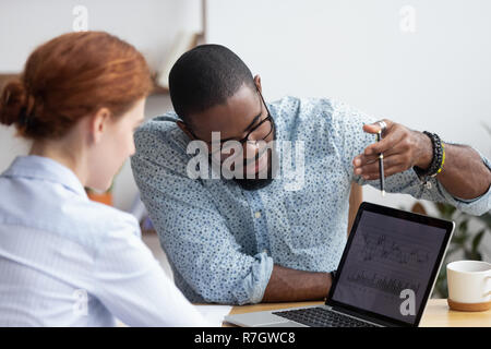 Colleagues working together analyzing data looking at laptop scr Stock Photo