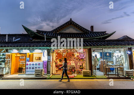 Seoul, South Korea - Sep 4th 2018 - A young woman walking in front of a colorful bright souvenir store in downtown Seoul in a late sunset Stock Photo
