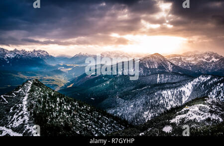 Mysterious mountain landscape with dramatic sunset sky in winter time, Herzogstand, Bavarian Alps, Germany Stock Photo