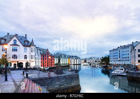 Alesun, Norway - July 20th, 2018: View of the Art Nouveau buildings reflected in the water at sunrise in summer, Alesund, Norway. Stock Photo