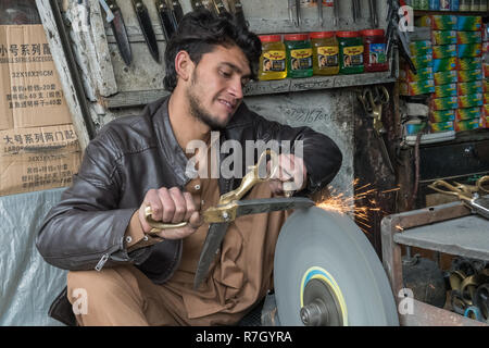 Young Knife Sharpener at Kabul's Bazaar, Kabul, Kabul Province, Afghanistan Stock Photo