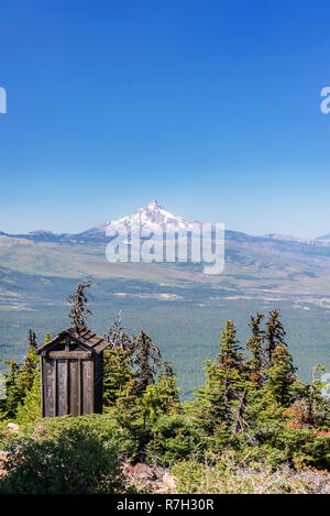 Vertical view of an outhouse and Mt. Jefferson as seen from Black Butte in Central Oregon Stock Photo