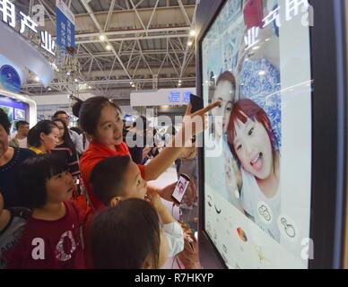 (181210) -- BEIJING, Dec. 10, 2018 (Xinhua) -- Visitors experience taking selfie with a phone app during the Digital China Exhibition in Fuzhou, capital of southeast China's Fujian Province, April 22, 2018. China's internet service and related sectors maintained sound growth in the first 10 months of the year, seeing a stable market expansion of online streaming apps, data showed. The sectors' revenue totaled 766.3 billion yuan (about 111.6 billion U.S. dollars) in the Jan.-Oct. period, up 18 percent year on year, according to the Ministry of Industry and Information Technology (MIIT). F Stock Photo