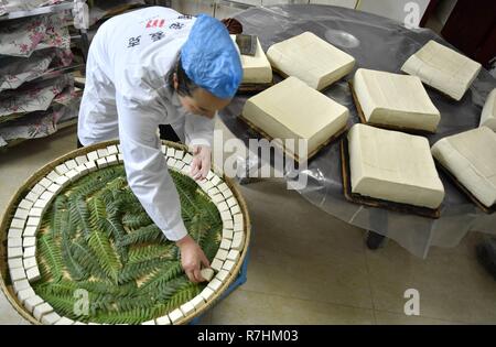 (181210) -- BEIJING, Dec. 10, 2018 (Xinhua) -- Local resident Yi Yinjie arranges fresh tofu to let them ferment and grow mildew in Zhushan Township of Xuan'en County in Enshi Tujia and Miao Autonomous Prefecture, central China's Hubei Province, Nov. 24, 2018. E-commerce and modern logistics have helped sell this specialty food to more customers. China's internet service and related sectors maintained sound growth in the first 10 months of the year, seeing a stable market expansion of online streaming apps, data showed. The sectors' revenue totaled 766.3 billion yuan (about 111.6 billion U.S Stock Photo