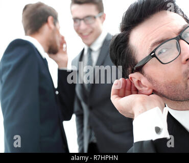 close up.businessman eavesdropping on conversation between colleagues Stock Photo