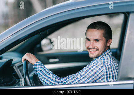 side view. a young man sitting behind the wheel of a car Stock Photo