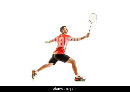 Young man playing badminton over white studio background. Fit male athlete isolated on white. badminton player in action, motion, movement. attack and defense concept Stock Photo