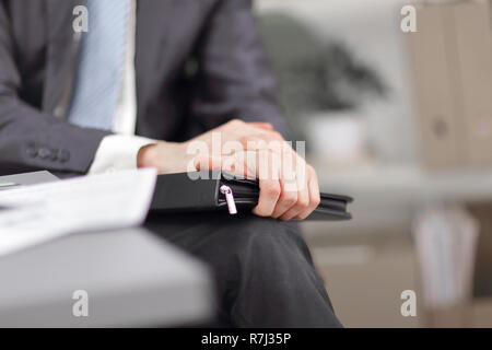 close up.A businessman with a leather briefcase sitting in an of Stock Photo