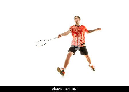 Young man playing badminton over white studio background. Fit male athlete isolated on white. badminton player in action, motion, movement. attack and defense concept Stock Photo