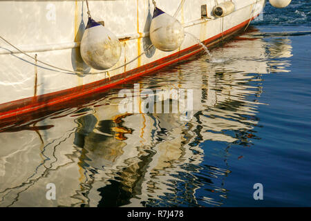 Boats reflecting in the water in a harbour Stock Photo