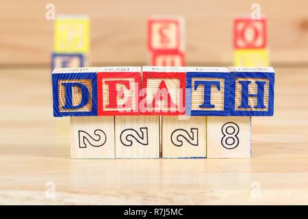 Wooden blocks with letters. Educational toy concept - children learning about death. Stock Photo