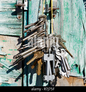 Bunch of old keys on a background of a green vintage wall Stock Photo